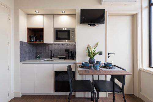 a kitchen with a table and chairs and a sink at DOISPONTOZERO Júlio Dinis in Porto