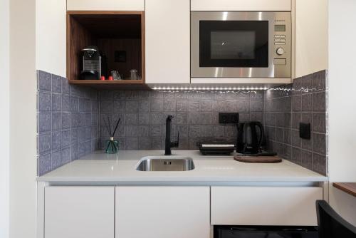 a kitchen with a sink and a microwave at DOISPONTOZERO Júlio Dinis in Porto