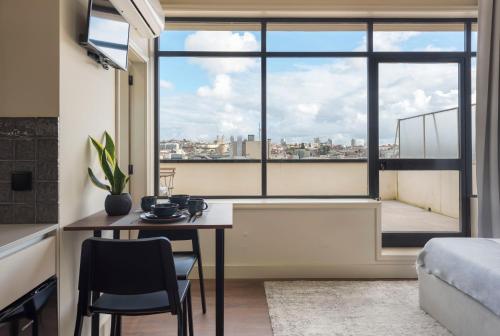 a living room with a table and a large window at DOISPONTOZERO Júlio Dinis in Porto