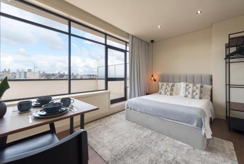 a hotel room with a bed and a table and window at DOISPONTOZERO Júlio Dinis in Porto