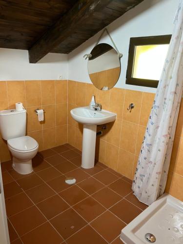 Encanto - Pinilla del Valle في Pinilla del Valle: حمام مع حوض ومرحاض ومرآة