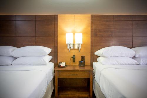 two beds in a hotel room with a telephone between them at Arroyo Pinion Hotel, an Ascend Collection Hotel in Sedona