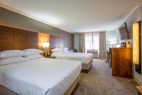 a hotel room with two beds and a desk at Arroyo Pinion Hotel, an Ascend Collection Hotel in Sedona