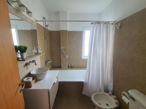 a bathroom with a tub and a sink and a toilet at Duplex Laguna in Puerto Madryn