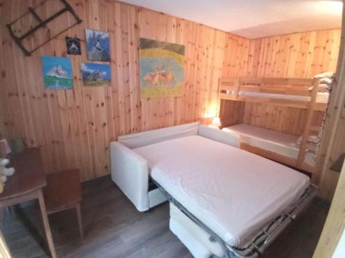 a room with a bunk bed in a wooden wall at Appartamento raccolto con terrazzo e parcheggio in Antey-Saint-André