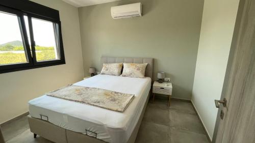 a small bedroom with a bed and a window at Thalassa Apartment in Nea Peramos