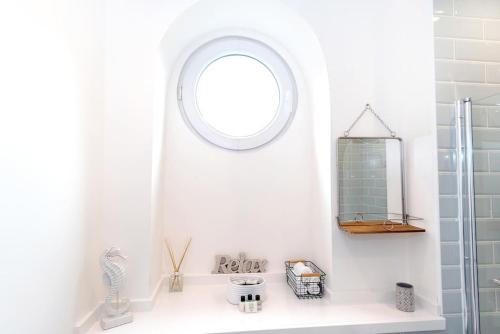 a bathroom with a round window and a sink at Cosy 200 Year Old Listed Cottage Near to St Andrews in Markinch