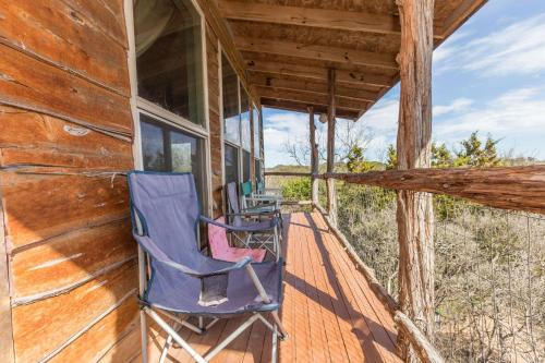 un porche de una cabaña con sillas. en The Cedar House at Creekside Camp & Cabins, en Marble Falls