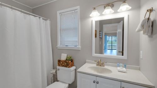 La salle de bains est pourvue d'un lavabo, de toilettes et d'un miroir. dans l'établissement Beachwood Villas 2A, à Santa Rosa Beach