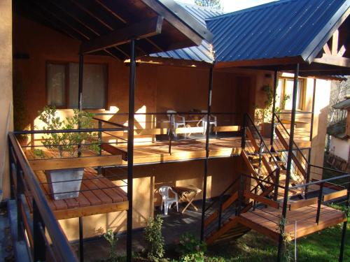 a house with a deck with a blue roof at Valle Puelo in Lago Puelo