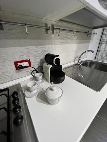 Il comprend une cuisine équipée d'une cuisinière et d'un évier. dans l'établissement Nel Cortile Suite, à Cefalù