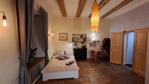 Schlafzimmer mit einem Bett und einem Kronleuchter in der Unterkunft Vintage Old Town Apartments in Vilnius