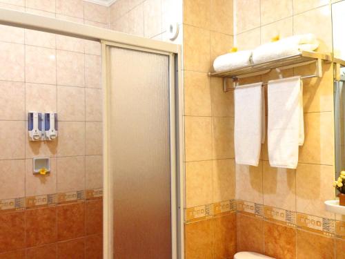 a bathroom with a shower and a toilet and towels at Ravarine Suite Apartment in Jakarta