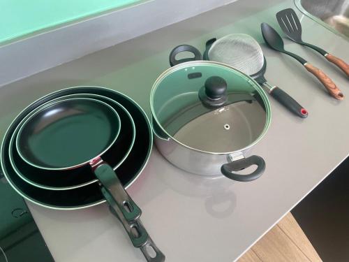a counter top with pots and pans and utensils at Pyramid Tamarindo Luxury Hotel in Tamarindo
