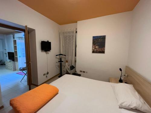 sypialnia z białym łóżkiem i telewizorem w obiekcie Appartamento Capri w Arco