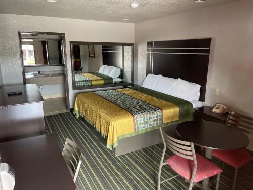 um quarto de hotel com uma cama, uma mesa e um espelho em REGENCY INN - CHANNELVIEW em Channelview