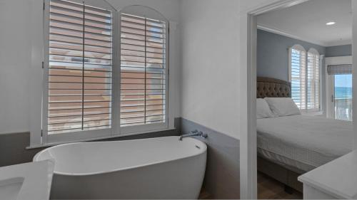 a bathroom with a tub and a bed and a window at Monterey Condos C301 in Seacrest