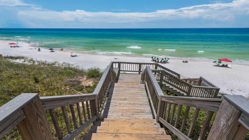 a wooden staircase leading to a beach with the ocean at Monterey Condos C301 in Seacrest