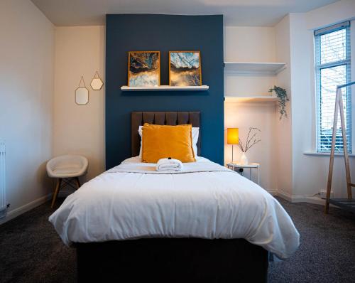 1 dormitorio con 1 cama con pared azul en Comfortable equipped House in Nuneaton sleeps5 with FREE parking, en Nuneaton
