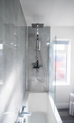 a bathroom with a shower and a bath tub at Well equipped home in Nuneaton sleeps5 FREE parking good amenites WiFi contractors - insurance companies - relocation agents in Nuneaton