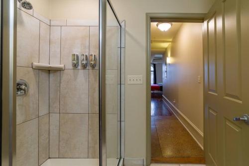 een badkamer met een douche en een glazen deur bij King bed w/ Panoramic Views of DT! in Rochester