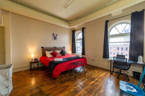 una camera da letto con letto con lenzuola rosse e scrivania di King bed w/ Panoramic Views of DT! a Rochester