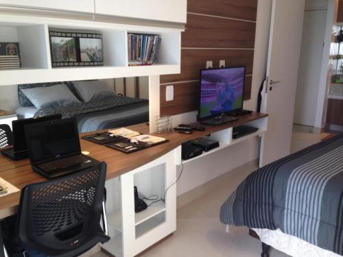 a bedroom with a desk with a computer and a bed at Landscape Beira Mar Fortaleza in Fortaleza