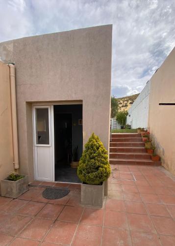 a building with a door and some plants and stairs at CDC Ambientes - Alojamiento Temporario in Rada Tilly