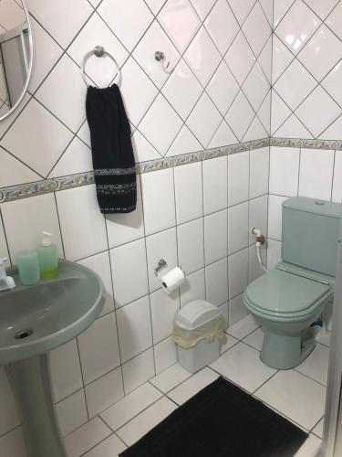 a bathroom with a green toilet and a sink at CocoFloripa Hostel in Florianópolis