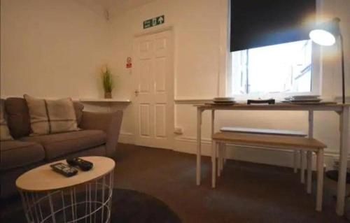 a living room with a couch and a table at CONTRACTORDIGS with FREE parking - excellent road links in Nuneaton