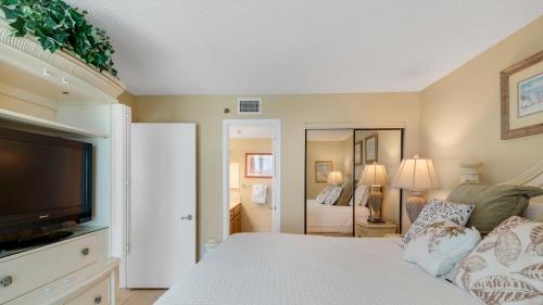 a bedroom with a bed and a tv and a bedroom at Beachcrest 903 in Santa Rosa Beach