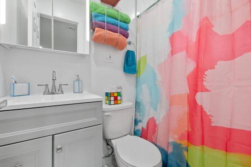 a bathroom with a rainbow shower curtain and a toilet at Private Studio Apartment Near NYC in Hoboken