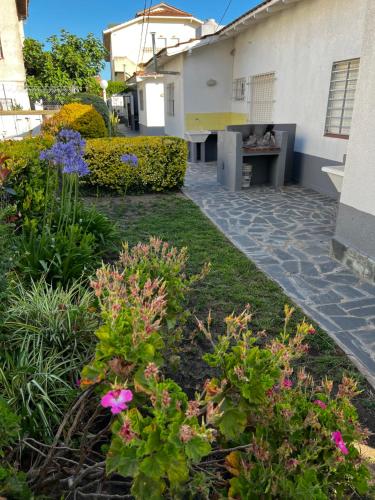 un jardín fuera de una casa con flores en el patio en PH a 1 cuadra de la playa, 2 con, patio y parrilla en Villa Gesell