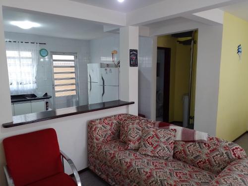 a living room with a couch and a kitchen at Casa Matinhos Caioba Parana in Matinhos