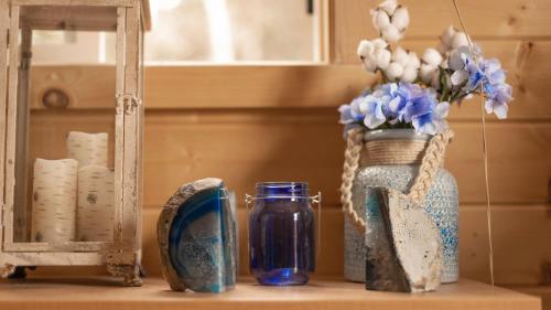 une table avec des vases, un miroir et un vase avec des fleurs dans l'établissement Charming Blue Farmhouse Cabin, à Duck Creek Village