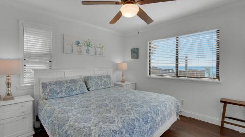 een slaapkamer met een bed en een plafondventilator bij Beachside Condo 1 in Santa Rosa Beach