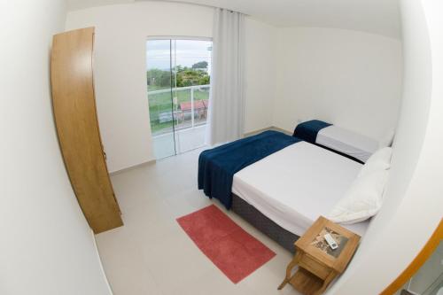 um pequeno quarto com 2 camas e uma janela em Apartamentos Sinhá em Penha
