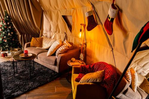 a room with a tent with two couches and a christmas tree at Agros Glamping Boutique in Agros
