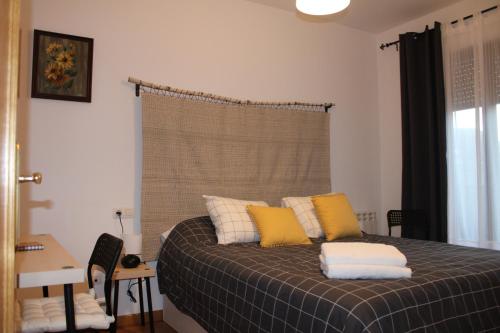 sypialnia z łóżkiem z żółtymi i białymi poduszkami w obiekcie La casa de los abedules w mieście León