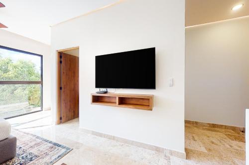 a living room with a flat screen tv on a wall at Giada Towers A204 in Tulum
