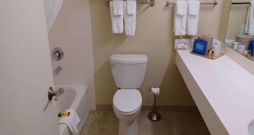 a bathroom with a toilet and a sink with towels at SureStay Hotel by Best Western Eureka in Eureka