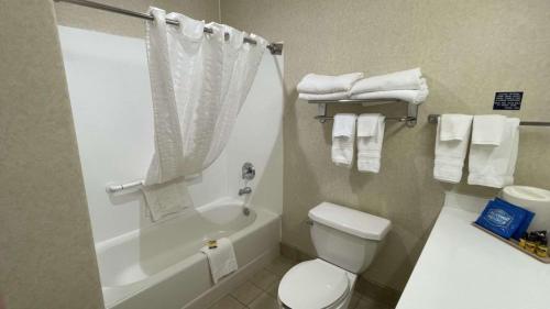 a bathroom with a toilet and a shower with towels at SureStay Hotel by Best Western Eureka in Eureka