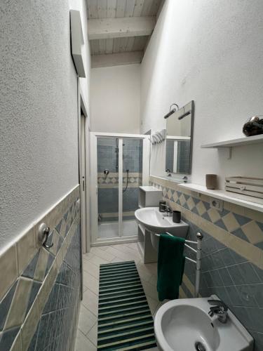 een badkamer met een wastafel, een toilet en een spiegel bij SPRITZ HOME in Viddalba