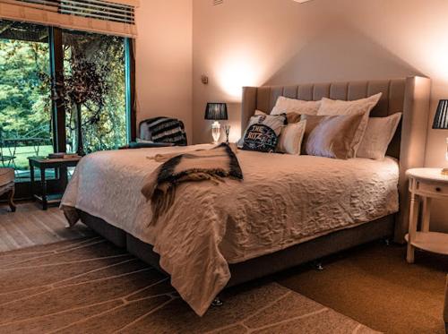 um quarto com uma cama grande e uma janela em Boutique LUXE HomeStay Stunning VIEWS ! Villa em Orbost