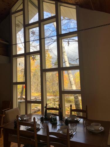 una sala da pranzo con tavolo e una grande finestra di Classic VT Aframe - Minutes to Mountains a Peru