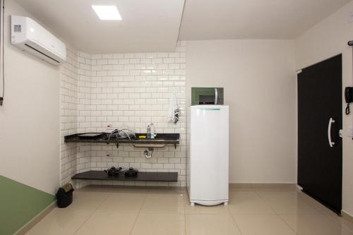 a kitchen with a white refrigerator in a room at Jahu Center Plaza Flats in Jaú