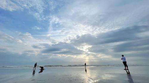 a group of people standing on the beach at Timurbay Treasures Studio Apartment Side Seaview with Wifi Neflix in Kuantan