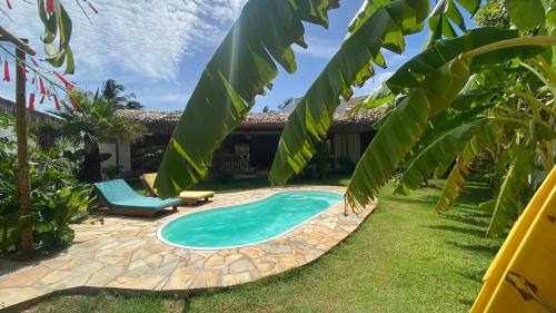 a pool in the backyard of a house with a palm tree at Casa Pura Vida - Icaraizinho in Icaraí