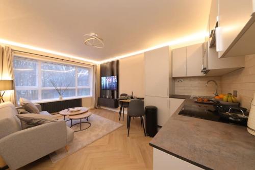 una cucina e un soggiorno con divano e tavolo di Riverside serviced apartments a Londra