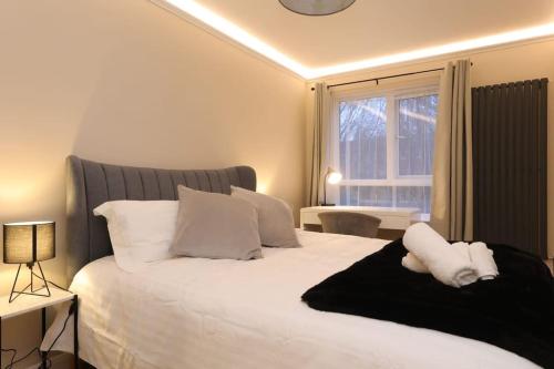 una camera da letto con un grande letto bianco e una finestra di Riverside serviced apartments a Londra